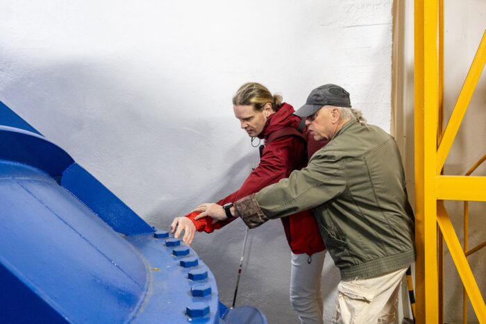 Nevidomý návštěvník hmatem prozkoumává objekt v elekrárně Štvanici, Open House Praha 2025